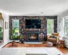 Living room with crown molding, a fireplace, baseboard heating, and wood-type flooring