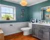 Bathroom featuring ornamental molding, hardwood / wood-style floors, toilet, and vanity