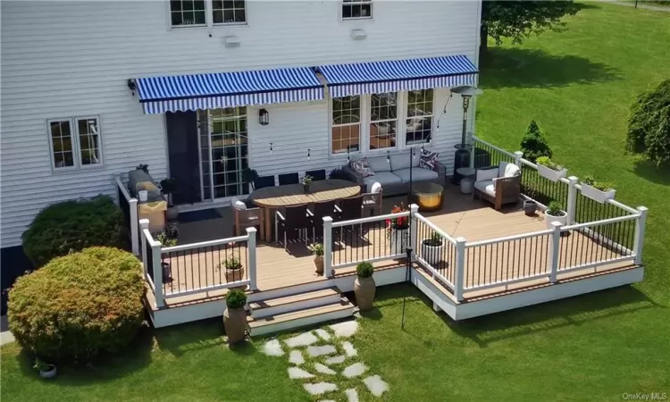 Rear view of property featuring a lawn, an outdoor hangout area, and a wooden deck