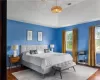 Bedroom featuring a baseboard heating unit, dark wood-type flooring, and a raised ceiling