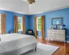 Bedroom with vaulted ceiling, hardwood / wood-style floors, and a baseboard heating unit