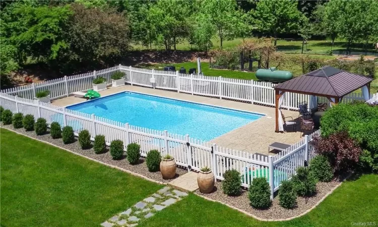 View of swimming pool featuring a patio, a gazebo, and a lawn