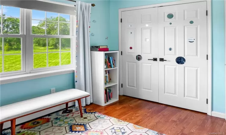 Living area with a baseboard heating unit and hardwood / wood-style flooring