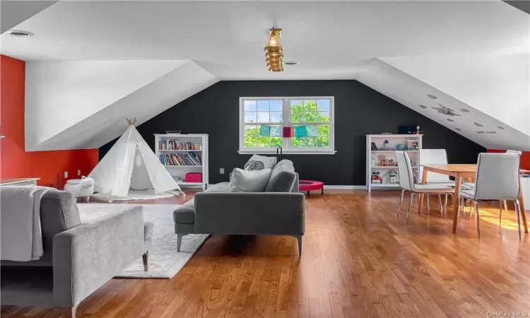 Living room with wood-type flooring and vaulted ceiling