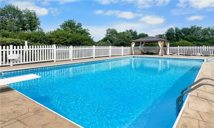 View of pool featuring a diving board and a gazebo