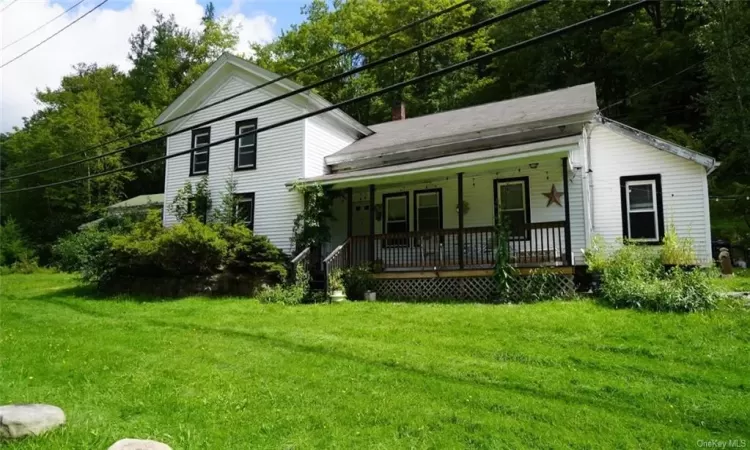 View of front of house with a front lawn and covered porch