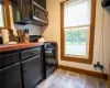 Kitchen with black gas stove and light hardwood / wood-style flooring