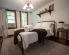 Bedroom with an inviting chandelier, crown molding, and wood-type flooring