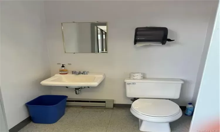 Bathroom featuring sink, tile flooring, baseboard heating, and toilet