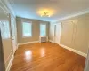 Unfurnished room with radiator heating unit, crown molding, and hardwood / wood-style flooring