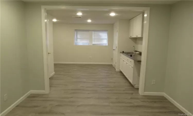 Kitchen featuring hardwood / wood-style floors, white cabinetry, and sink