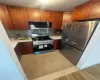 Kitchen featuring appliances with stainless steel finishes, backsplash, and light tile floors