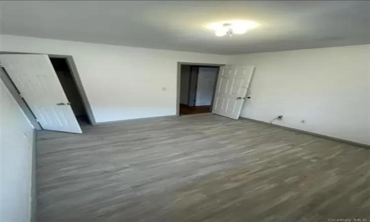 Unfurnished bedroom featuring dark hardwood / wood-style floors