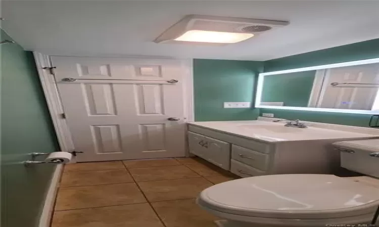 Bathroom featuring tile flooring, oversized vanity, and toilet