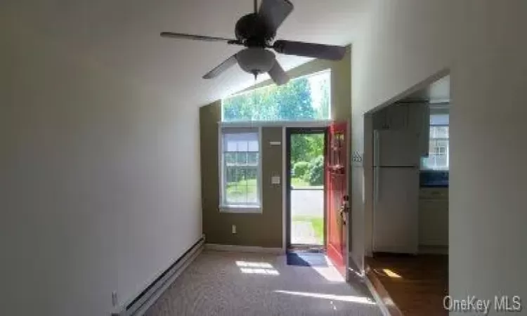 Doorway with a baseboard heating unit, carpet, plenty of natural light, and ceiling fan