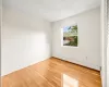 Empty room featuring a baseboard heating unit, light hardwood / wood-style floors, and a textured ceiling