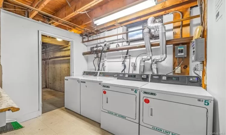 Clothes washing area with washing machine and dryer and light tile floors