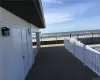 Wooden terrace featuring a beach view and a water view