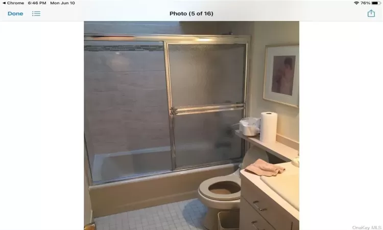 Full bathroom featuring tile floors, combined bath / shower with glass door, vanity, and toilet