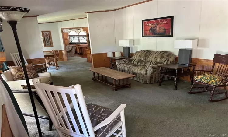 Living room with crown molding and carpet floors