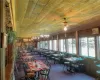 Sunroom / solarium featuring wooden ceiling and ceiling fan with notable chandelier