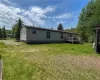 Back of property featuring a lawn and a wooden deck