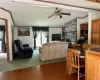 Living room featuring a textured ceiling, a fireplace, lofted ceiling, hardwood / wood-style flooring, and ceiling fan