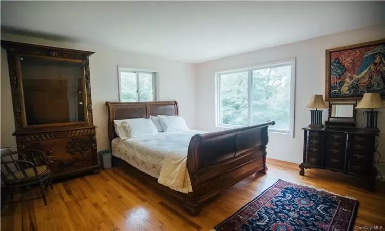 Living room with wood-type flooring, ceiling fan, a fireplace, and vaulted ceiling