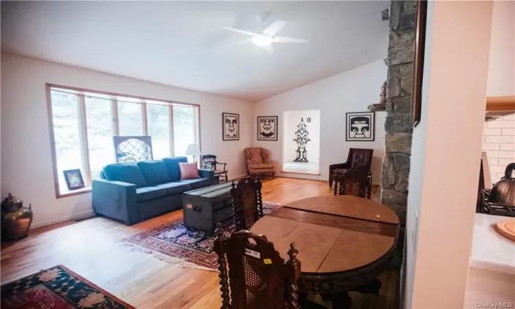 Dining room featuring light hardwood / wood-style flooring, a fireplace, and brick wall