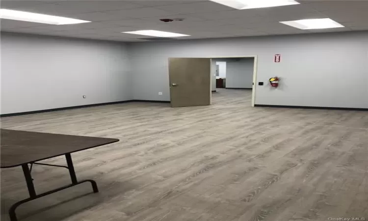 Empty room with hardwood / wood-style flooring and a drop ceiling