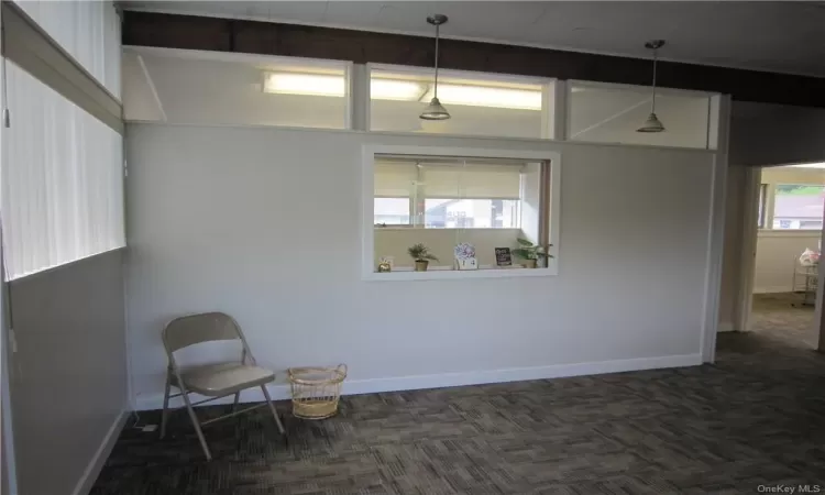 Unfurnished room featuring dark carpet