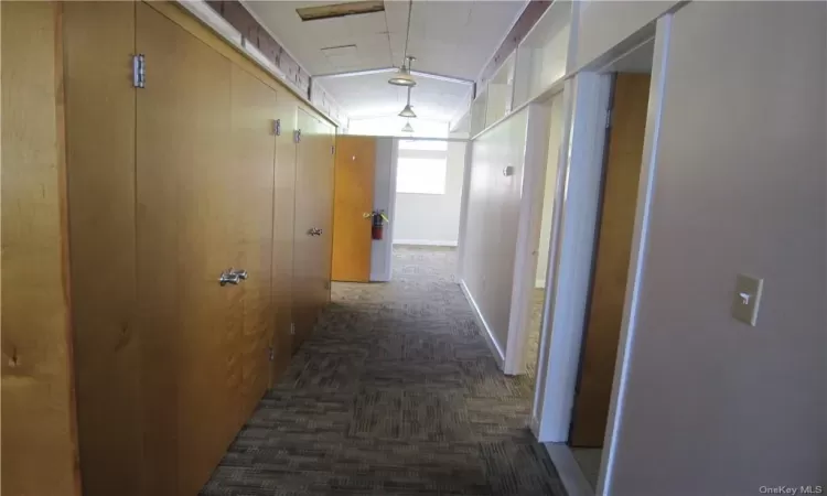 Hall with vaulted ceiling and dark carpet