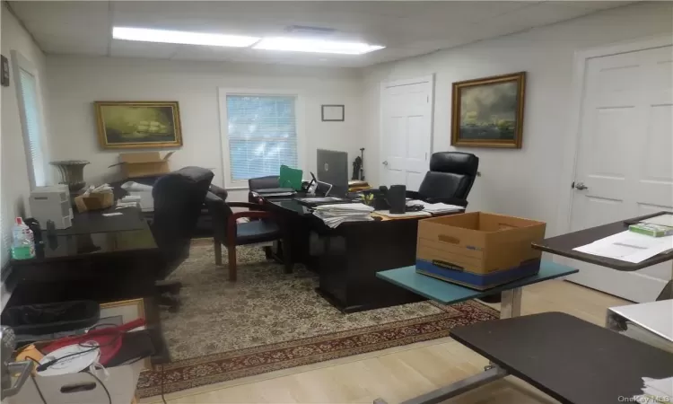 Office featuring hardwood / wood-style floors and a paneled ceiling