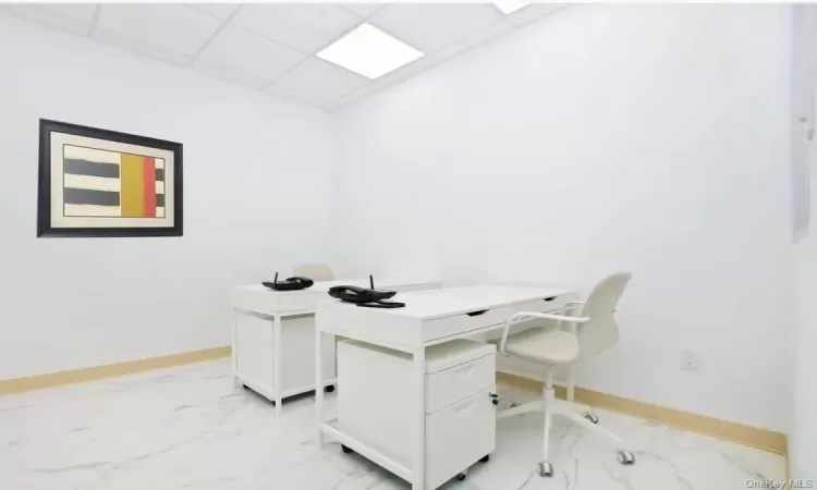 Office space with light tile flooring and a paneled ceiling