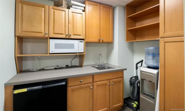 Kitchen featuring sink, black dishwasher, and white microwave