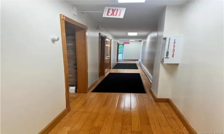 Corridor featuring baseboard heating and light hardwood / wood-style floors