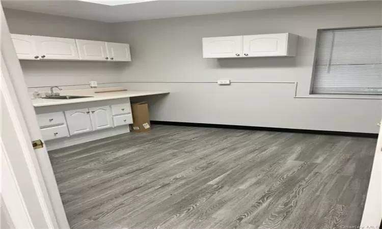 Kitchen featuring sink, hardwood / wood-style floors, and white cabinets