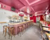 Bar with concrete flooring, beam ceiling, pendant lighting, a wall mounted air conditioner, and coffered ceiling