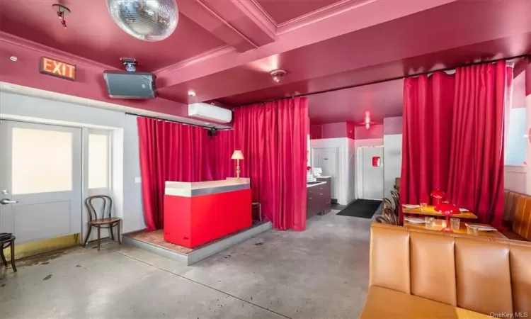 Garage with white fridge and a wall mounted air conditioner