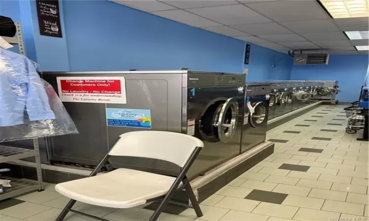 Clothes washing area with light tile patterned floors