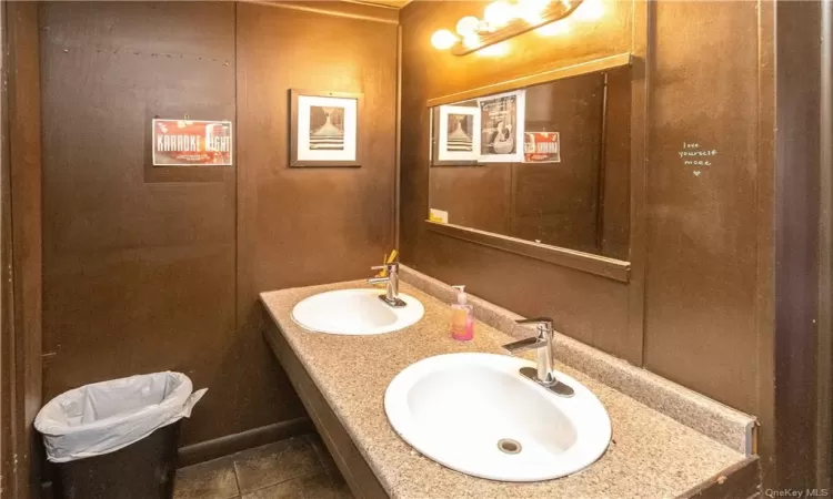 Bathroom with tile patterned floors and double sink vanity