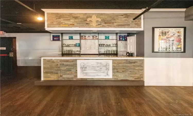 Bar featuring dark wood-type flooring