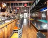 Bar with hardwood / wood-style flooring and billiards