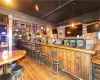 Bar featuring hardwood / wood-style floors, pendant lighting, and brick wall