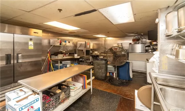 Basement with a drop ceiling and high end fridge