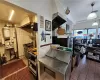 Kitchen with stainless steel counters, tile patterned flooring, tile walls, sink, and decorative light fixtures