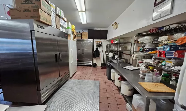 Kitchen with high end fridge and tile patterned flooring