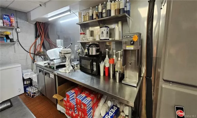 Kitchen with a drop ceiling, refrigerator, and dark tile patterned flooring