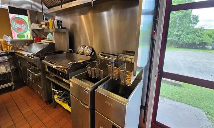 Kitchen with dark tile patterned flooring and dark brown cabinetry