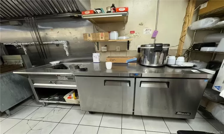 Kitchen featuring stainless steel counters and light tile patterned flooring